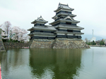 写真：水面に映る松本城とまだ残る桜